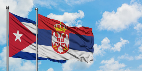 Cuba and Serbia flag waving in the wind against white cloudy blue sky together. Diplomacy concept, international relations.
