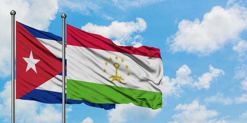 Cuba and Tajikistan flag waving in the wind against white cloudy blue sky together. Diplomacy...