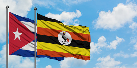 Cuba and Uganda flag waving in the wind against white cloudy blue sky together. Diplomacy concept, international relations.