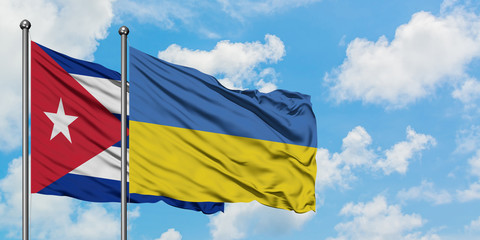 Cuba and Ukraine flag waving in the wind against white cloudy blue sky together. Diplomacy concept, international relations.