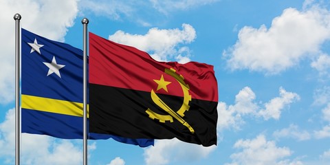 Curacao and Angola flag waving in the wind against white cloudy blue sky together. Diplomacy concept, international relations.