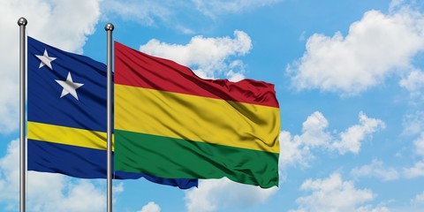 Curacao and Bolivia flag waving in the wind against white cloudy blue sky together. Diplomacy concept, international relations.