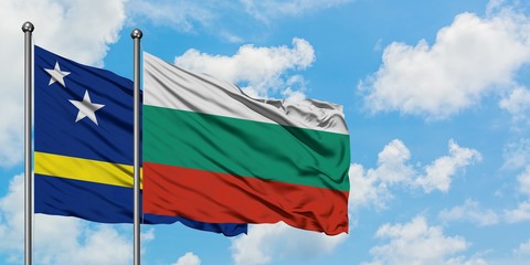 Curacao and Bulgaria flag waving in the wind against white cloudy blue sky together. Diplomacy concept, international relations.