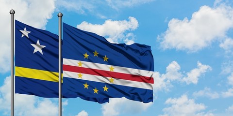 Curacao and Cape Verde flag waving in the wind against white cloudy blue sky together. Diplomacy concept, international relations.