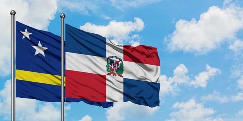Curacao and Dominican Republic flag waving in the wind against white cloudy blue sky together. Diplomacy concept, international relations.