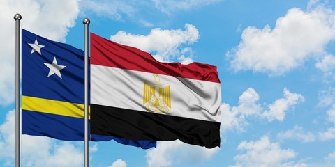 Curacao and Egypt flag waving in the wind against white cloudy blue sky together. Diplomacy concept, international relations.