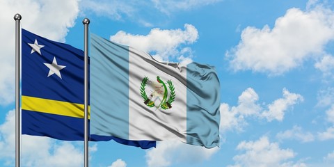 Curacao and Guatemala flag waving in the wind against white cloudy blue sky together. Diplomacy concept, international relations.
