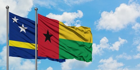 Curacao and Guinea Bissau flag waving in the wind against white cloudy blue sky together. Diplomacy concept, international relations.