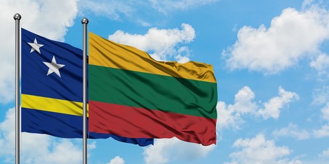 Curacao and Lithuania flag waving in the wind against white cloudy blue sky together. Diplomacy concept, international relations.