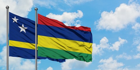 Curacao and Mauritius flag waving in the wind against white cloudy blue sky together. Diplomacy concept, international relations.