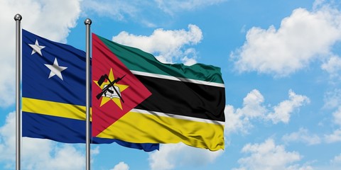 Curacao and Mozambique flag waving in the wind against white cloudy blue sky together. Diplomacy concept, international relations.