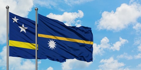Curacao and Nauru flag waving in the wind against white cloudy blue sky together. Diplomacy concept, international relations.