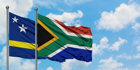 Curacao and South Africa flag waving in the wind against white cloudy blue sky together. Diplomacy concept, international relations.