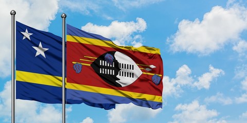 Curacao and Swaziland flag waving in the wind against white cloudy blue sky together. Diplomacy concept, international relations.