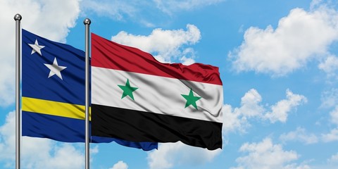 Curacao and Syria flag waving in the wind against white cloudy blue sky together. Diplomacy concept, international relations.