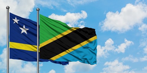 Curacao and Tanzania flag waving in the wind against white cloudy blue sky together. Diplomacy concept, international relations.