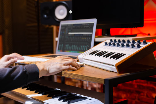 male composer, producer, arranger, song writer, musician hands arranging music on computer in home studio. music production concept