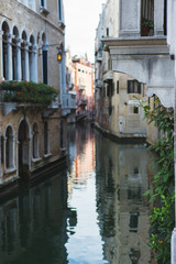 Fototapeta na wymiar View of the canals and buildings of Venice. Beautiful historic brick buildings on the narrow streets and canals of the ancient city. Warm autumn day, travel to Italy.