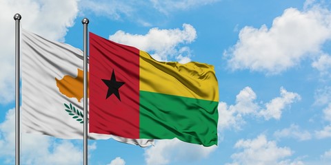 Cyprus and Guinea Bissau flag waving in the wind against white cloudy blue sky together. Diplomacy concept, international relations.