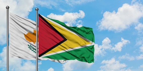 Cyprus and Guyana flag waving in the wind against white cloudy blue sky together. Diplomacy concept, international relations.