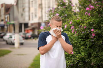 Young man suffering from allergy outdoors