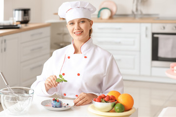 Female confectioner cooking tasty dessert in kitchen