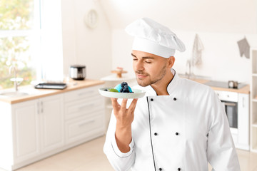 Male confectioner with tasty dessert in kitchen
