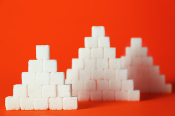 Stacked sugar cubes on color background