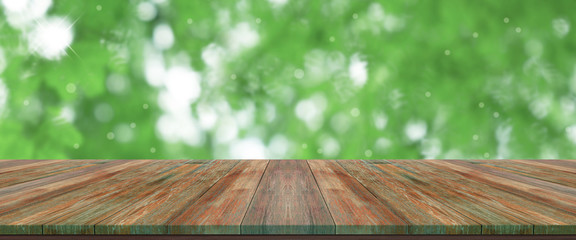 top wooden long table with natural green bokeh abstract background