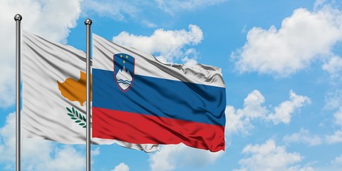 Cyprus and Slovenia flag waving in the wind against white cloudy blue sky together. Diplomacy concept, international relations.