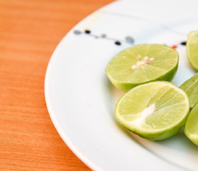 Lime in white dish on wood blackground