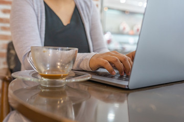 Woman working on laptop while sitting at coffee table