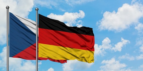Czech Republic and Germany flag waving in the wind against white cloudy blue sky together. Diplomacy concept, international relations.