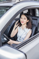 Fototapeta na wymiar LWTWL0009577 businesswoman driving car and talking on cell phone