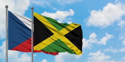 Czech Republic and Jamaica flag waving in the wind against white cloudy blue sky together. Diplomacy concept, international relations.