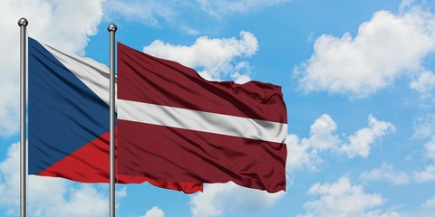 Czech Republic and Latvia flag waving in the wind against white cloudy blue sky together. Diplomacy concept, international relations.