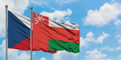 Czech Republic and Oman flag waving in the wind against white cloudy blue sky together. Diplomacy concept, international relations.