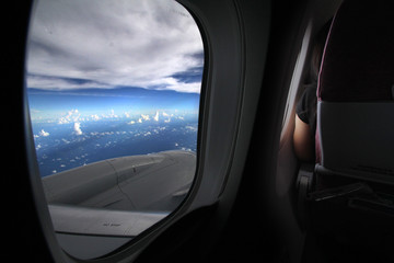 Fototapeta premium Sitting on the plane of the plane, sitting in the window seat, admiring the beautiful sea of ​​clouds and the travel companions that are not known to the common journey.
