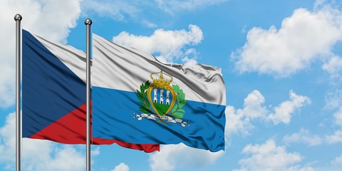 Czech Republic and San Marino flag waving in the wind against white cloudy blue sky together. Diplomacy concept, international relations.