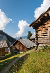 Obraz premium traditional wooden houses in Switzerland with blue sky and cumulus clouds in background