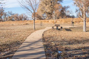 Picnic table by cement path at Barr Lake State Park, Colorado. Fall 2019