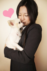 白い犬のチワワを愛するスーツの女性