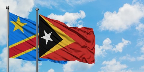 Congo and East Timor flag waving in the wind against white cloudy blue sky together. Diplomacy concept, international relations.