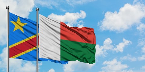 Congo and Madagascar flag waving in the wind against white cloudy blue sky together. Diplomacy concept, international relations.