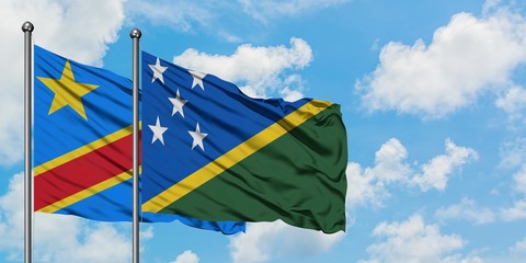 Congo and Solomon Islands flag waving in the wind against white cloudy blue sky together. Diplomacy concept, international relations.