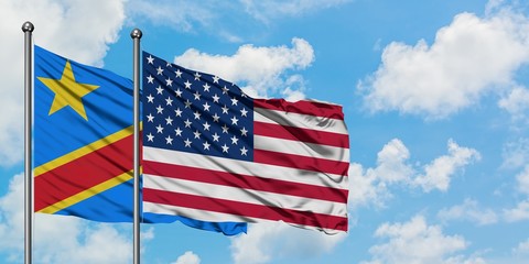 Obraz premium Congo and United States flag waving in the wind against white cloudy blue sky together. Diplomacy concept, international relations.