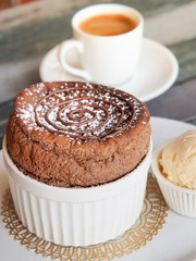 Chocolate Souffle with vanilla ice cream on white plate . French traditional dessert.