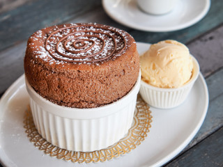 Chocolate Souffle with vanilla ice cream on white plate . French traditional dessert.