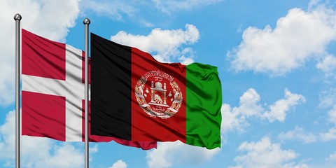 Denmark and Afghanistan flag waving in the wind against white cloudy blue sky together. Diplomacy concept, international relations.
