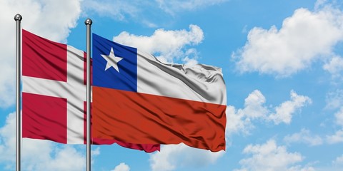 Denmark and Chile flag waving in the wind against white cloudy blue sky together. Diplomacy concept, international relations.